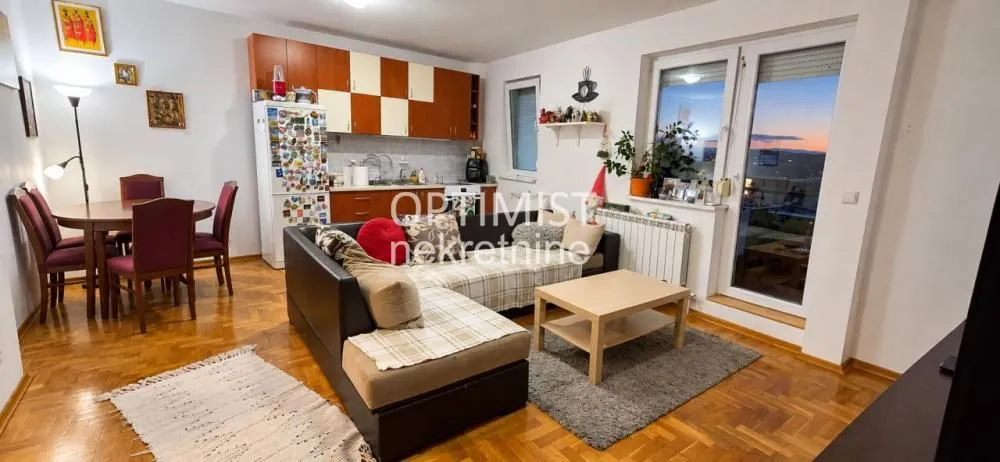 Dnevna soba sa garniturom, trpezarijom i ugrađenom kuhinjom.