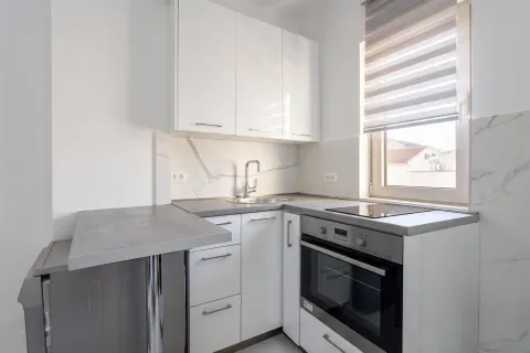 Moderna bijela kuhinja sa ugrađenom rernom, sudoperom i radnom površinom. - image 3