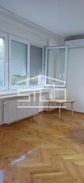 Empty room with parquet flooring, windows and a radiator. - image 12