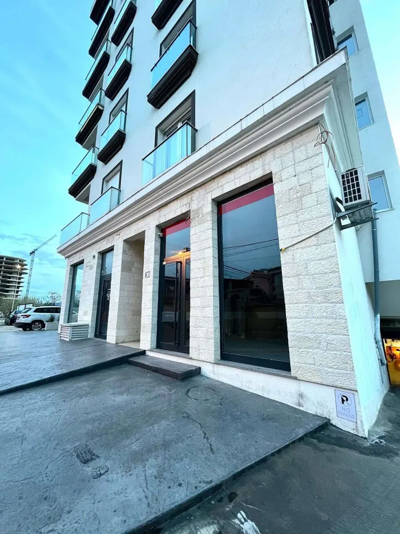 Exterior of a modern residential building with commercial space on the ground floor.