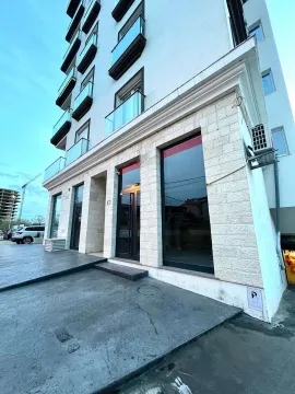 Exterior of a modern residential building with commercial space on the ground floor. - image 5