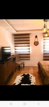 Namještena spavaća soba sa krevetom, komodom i televizorom. - image 10