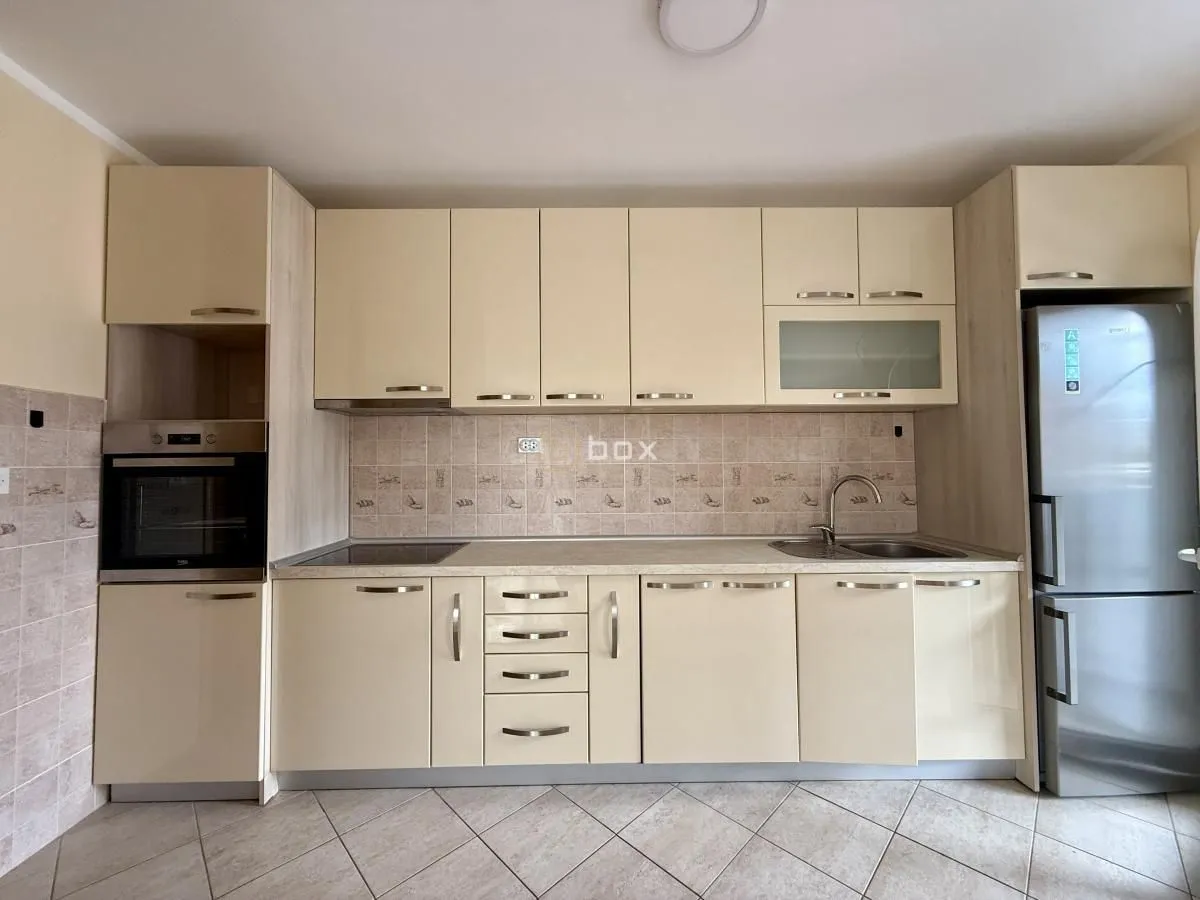 Equipped kitchen with light-colored cabinetry and built-in home appliances.