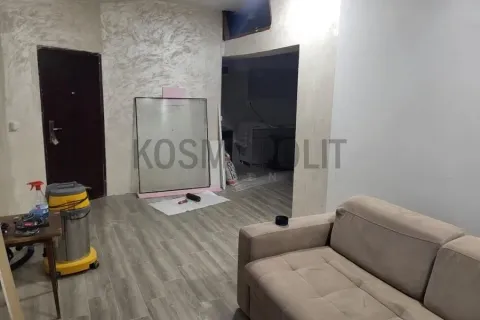 Living room with a sofa and entrance door during renovation. - image 9