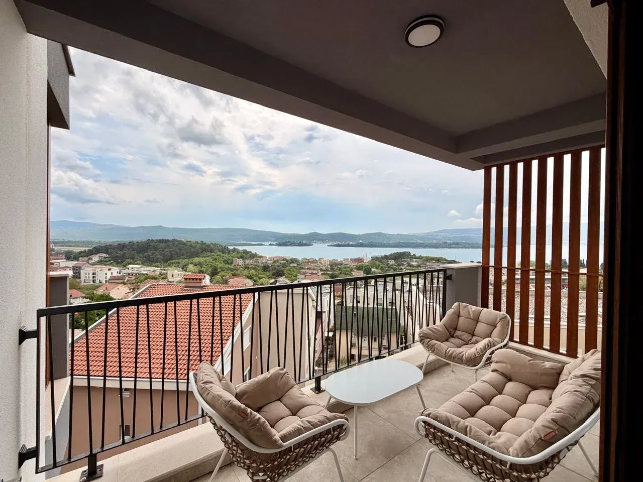 Furnished balcony with seating set and sea view.
