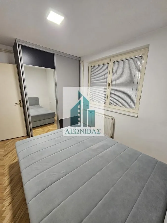 Furnished bedroom with a double bed, wardrobe, and window.