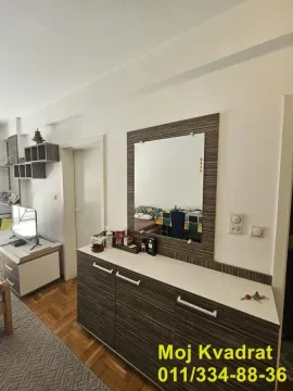 Pogled na deo dnevne sobe sa komodom, ogledalom i televizorom. - image 3
