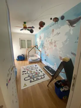 Svijetla dječija soba sa dekorativnim tapetama mape svijeta i krevetom u obliku kućice. - image 4