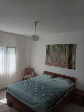 Spavaća soba sa bračnim krevetom, foteljom i prozorom sa zavjesama. - image 6