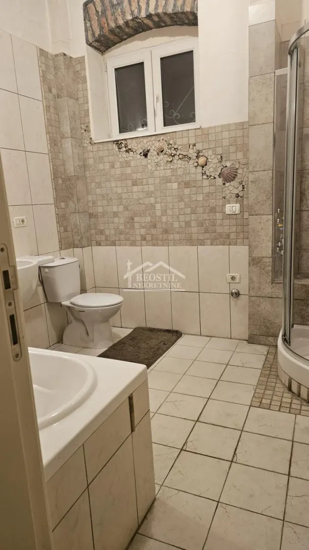 Kupatilo sa tuš kabinom, umivaonikom i toaletom.