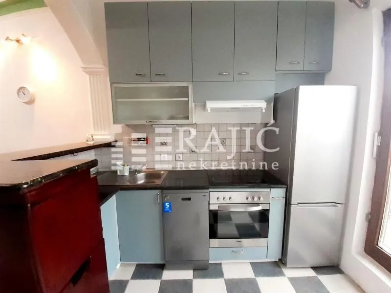 Small kitchen with grey cabinetry and built-in appliances.