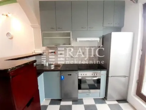Small kitchen with grey cabinetry and built-in appliances. - image 8