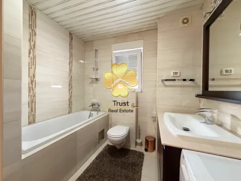 Brightly equipped bathroom with a bathtub, washbasin, and toilet. - image 16
