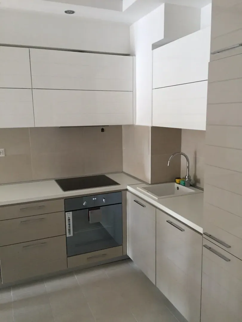 Modern kitchen with light cabinets and built-in appliances.