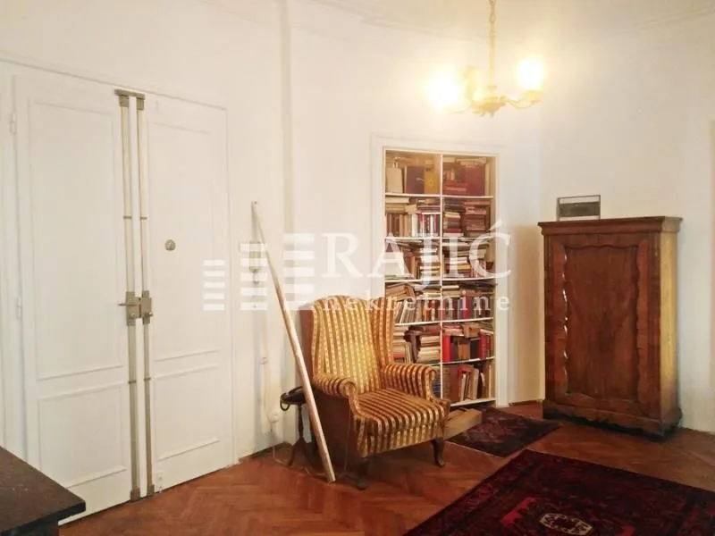 Living room with antique furniture, an armchair, and a bookcase.