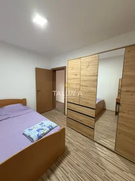 Bedroom with a bed and a wooden wardrobe with a mirror. - image 13