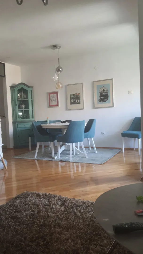 A bright dining area featuring blue chairs and a green cabinet.