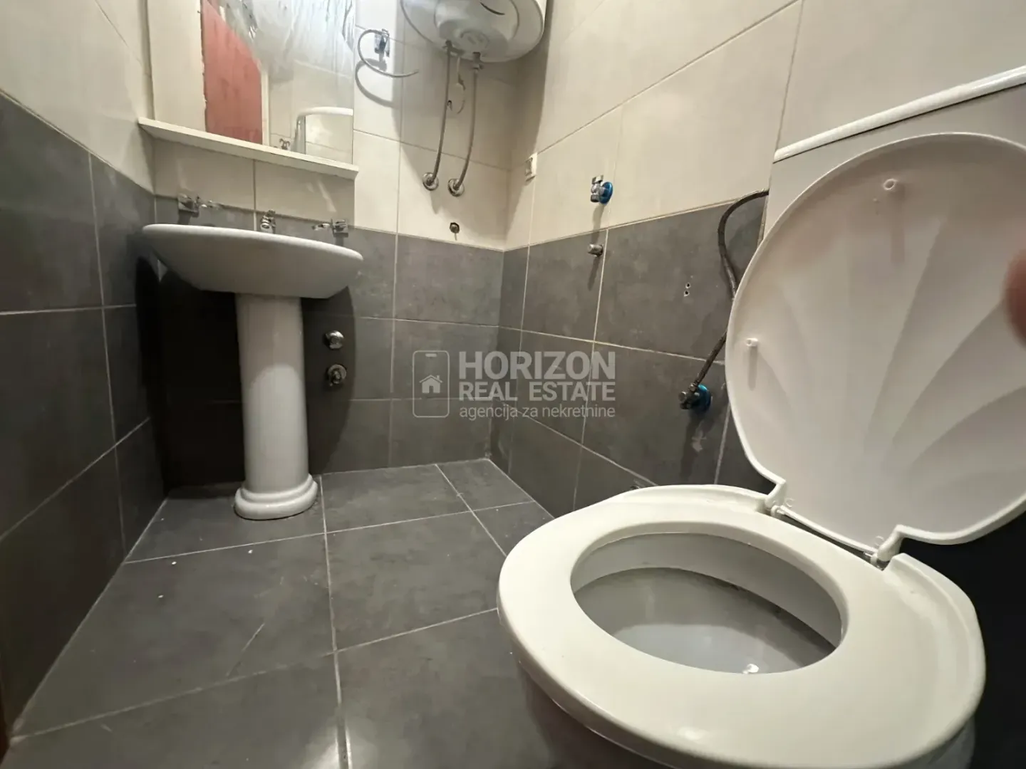 Smaller bathroom with a sink and toilet bowl.