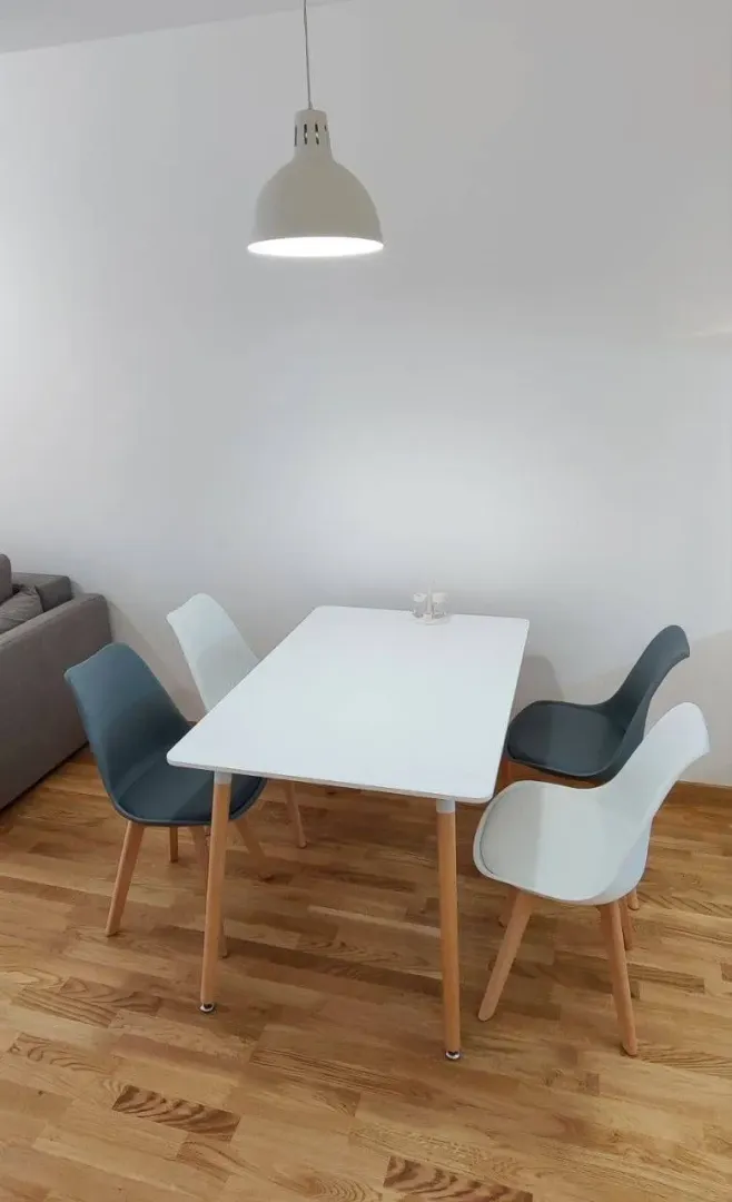 Trpezarija sa bijelim stolom i modernim stolicama.