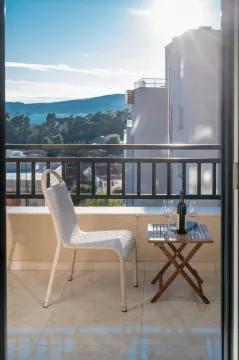 Namješten balkon sa stolom, stolicom i pogledom na more. - image 3