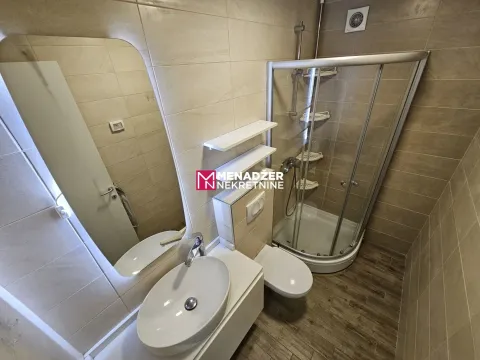 Modernly equipped bathroom with a shower cabin and a washbasin. - image 4