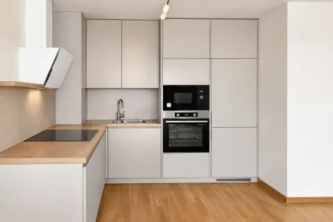 Moderna kuhinja u svijetlim tonovima sa ugradnim aparatima i drvenim podom. - image 3