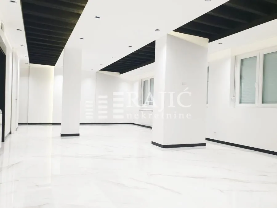 Spacious and bright empty space with white flooring and columns.