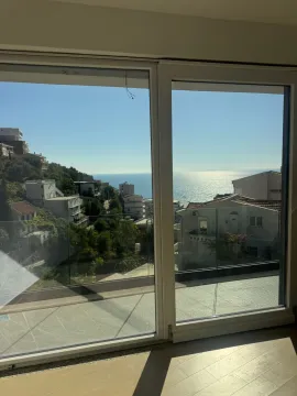 Pogled na more i okolne zgrade kroz veliki prozor sa terase. - image 12