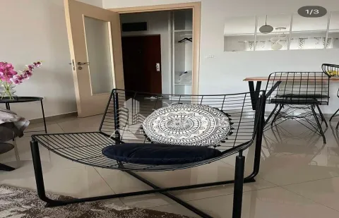 Dnevni boravak sa modernom foteljom i trpezarijskim stolom u pozadini. - image 3