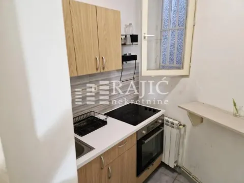 Smaller equipped kitchen with cabinets and a built-in stovetop. - image 7