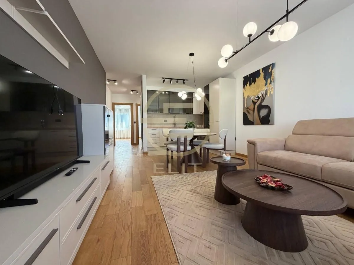 Living room with a sofa, television, and an adjacent dining area.