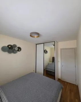 Namještena spavaća soba sa bračnim krevetom, ormarom i zidnim ukrasima. - image 10