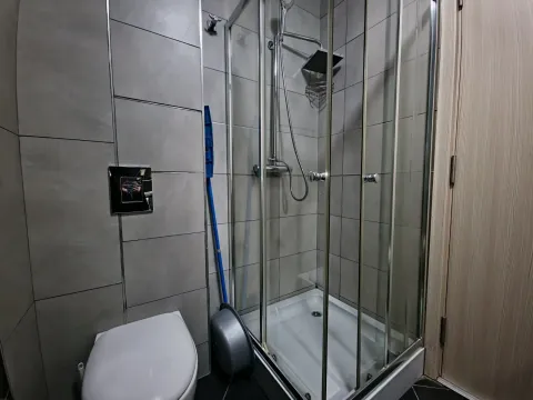 Modern bathroom with a shower cabin and a built-in toilet. - image 5