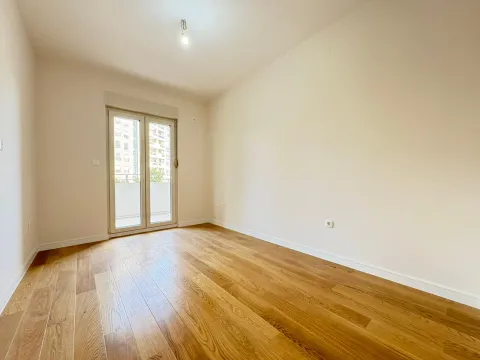 Prazna soba sa parketom i balkonskim vratima. - image 2