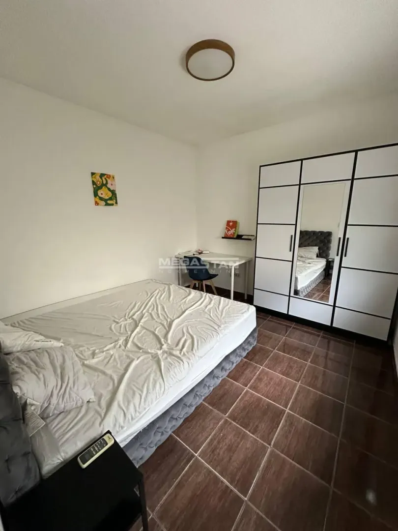 Nameštena spavaća soba sa bračnim krevetom, garderoberom i radnim stolom.