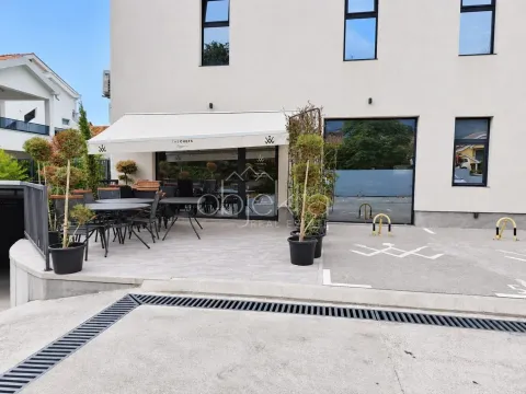 Exterior view of the building with a restaurant terrace and parking space. - image 2