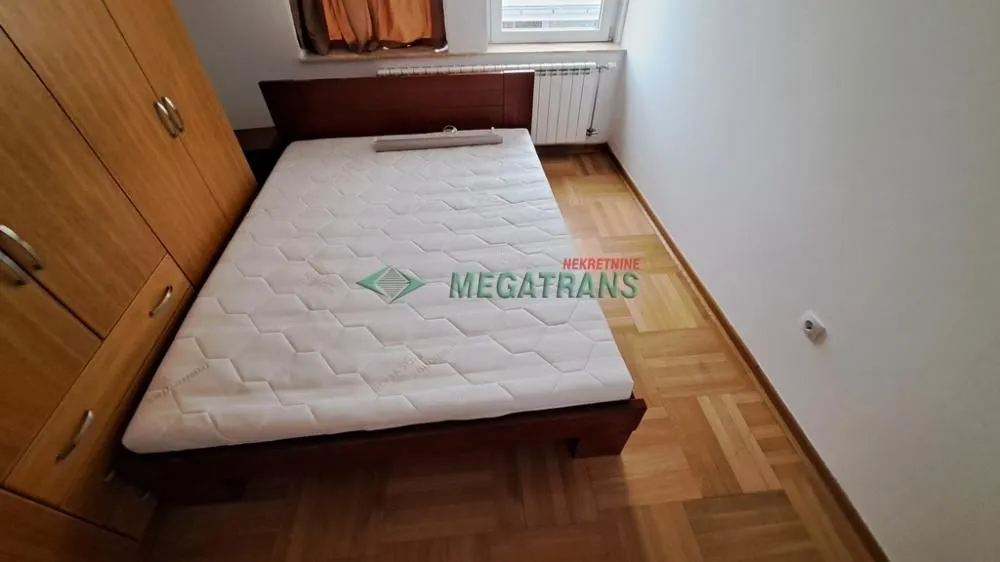 Bedroom with a double bed and a wooden wardrobe.