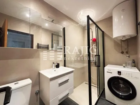 Modern bathroom with a shower cabin, washbasin, and washing machine. - image 12