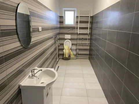 Modern bathroom with a sink, toilet, and tiled walls. - image 7