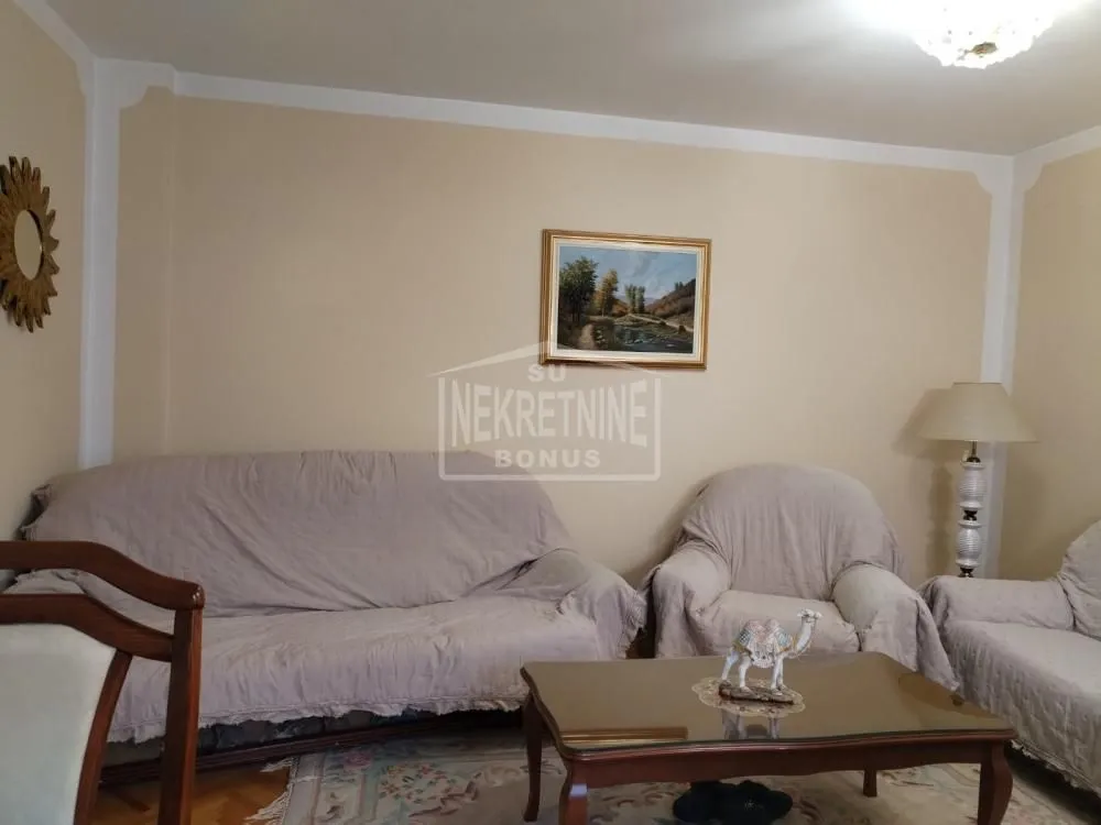 Dnevna soba sa garniturom za sedenje i stočićem.