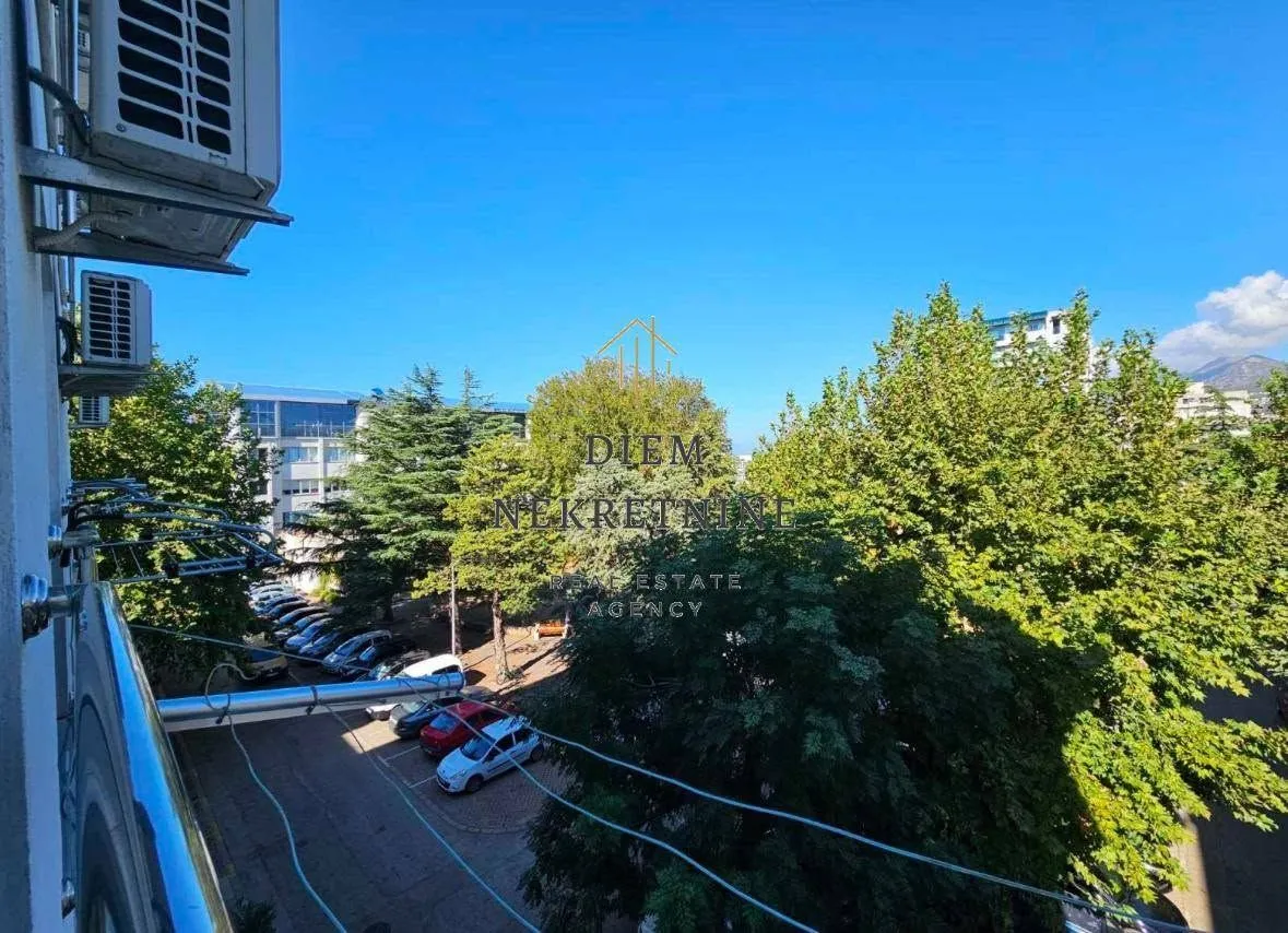 View from the terrace overlooking surrounding greenery and parking.