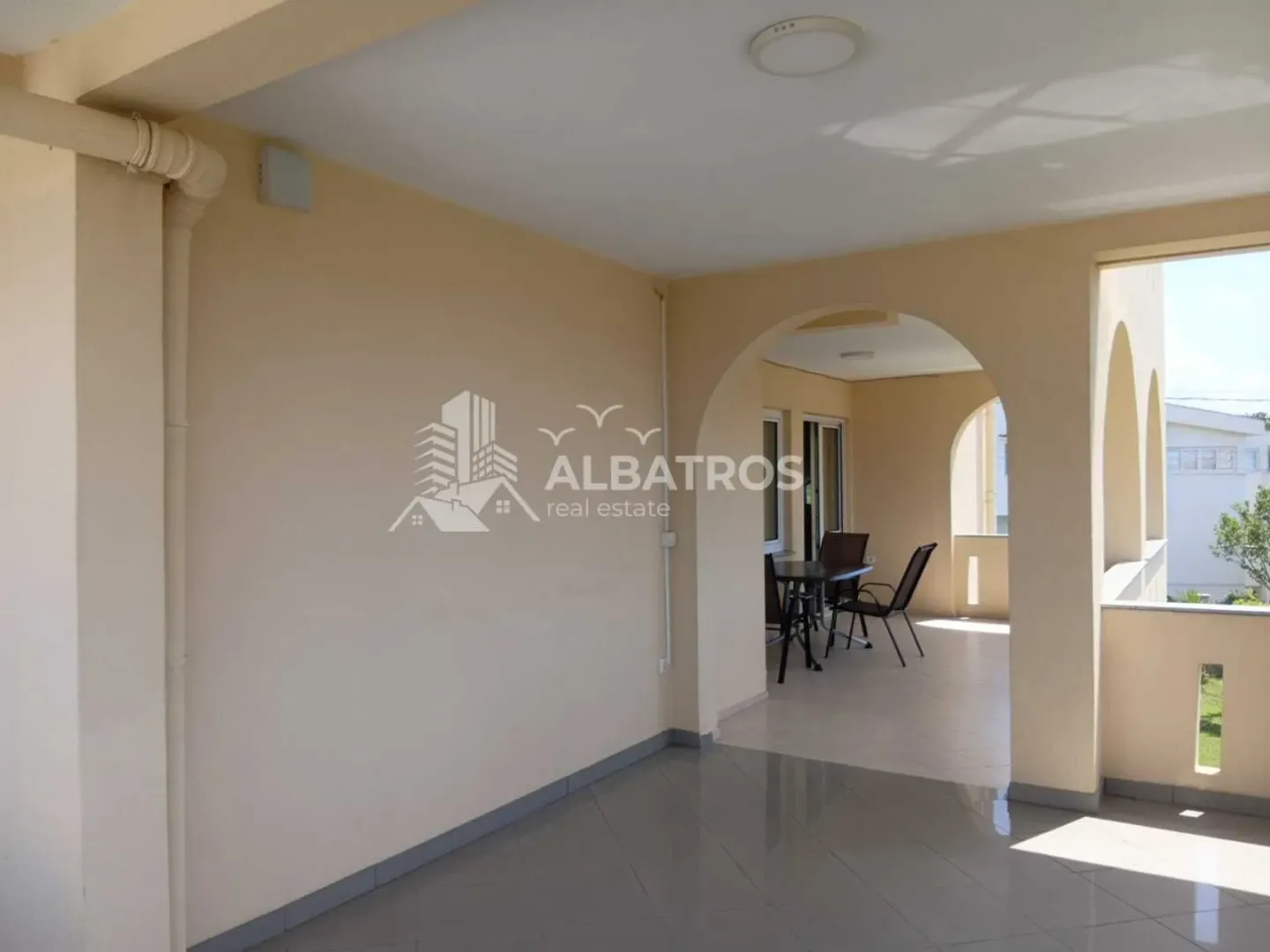 Covered terrace with ceramic tiles and arched walkways.