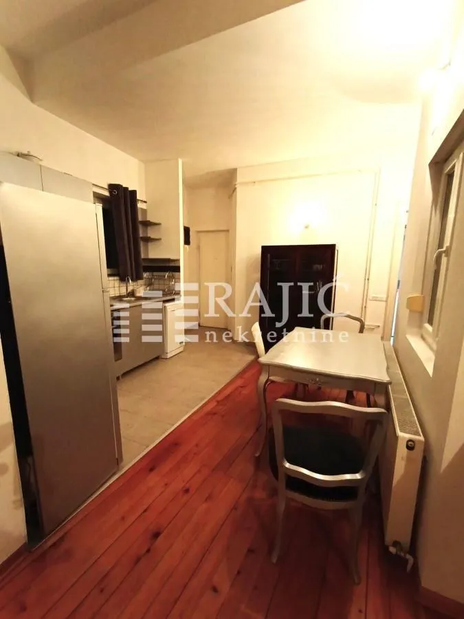 Kitchen with dining area and wooden floor.