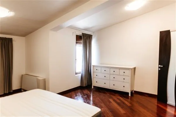 Bright bedroom with wooden flooring and a white chest of drawers.