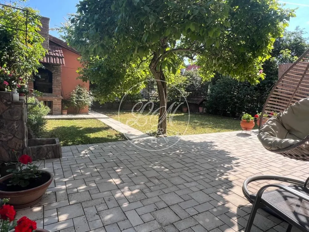 Landscaped courtyard with a paved area, lawn, and trees.