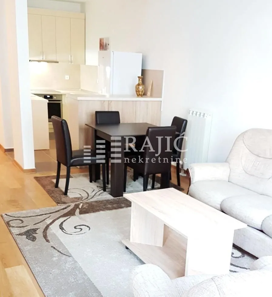 Living room with dining area and kitchen in the background.