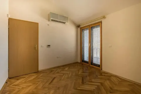Empty room with wooden parquet flooring, an air conditioning unit, and balcony doors. - image 10