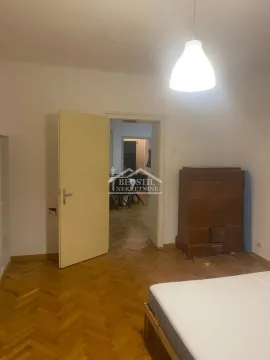 Spavaća soba sa krevetom, peći na drva i pogledom kroz vrata na drugu prostoriju. - image 8