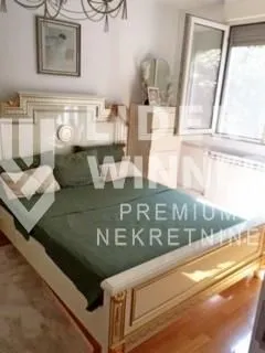Nameštena spavaća soba sa bračnim krevetom, komodom i prozorom. - image 3