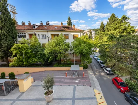 Pogled iz ptičje perspektive na zgradu, dvorište i okolnu ulicu sa parkiranim automobilima. - image 2